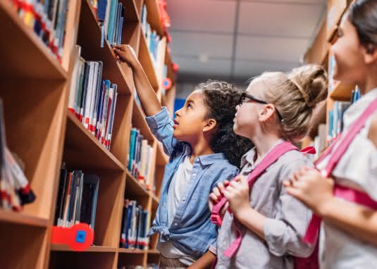 Schüler vor Bücherregal