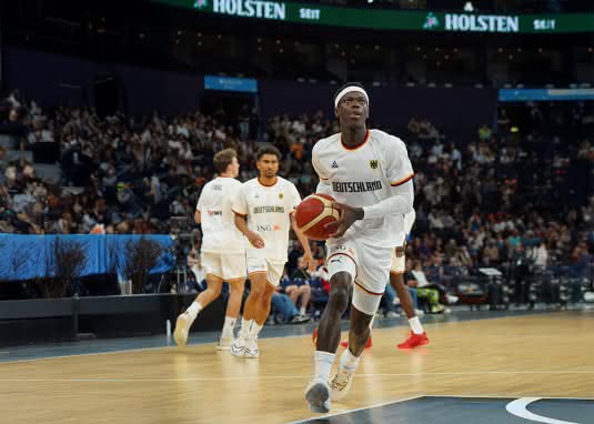 Basketballstar Dennis Schröder auf dem Spielfeld – in Bewegung, mit entschlossenem Blick.
